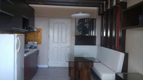 a kitchen with a glass table and a white door at Avida San Lazaro 1 BEDROOM with balcony near SM San Lazaro in Manila