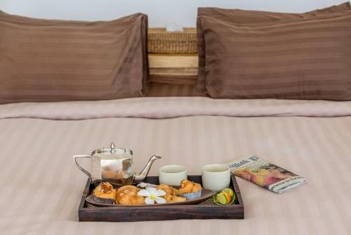 een dienblad met eten en twee kopjes op een bed bij Luxury SeaView Villa -Double Infinity Pools-20 Persons in Chaweng Beach