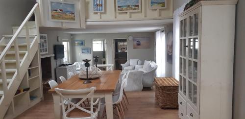 a dining room with a table and white chairs at Pondok in Paternoster