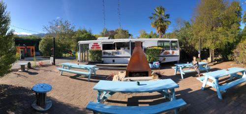 a food truck with tables and benches in front of it at Adventure Inn Marahau in Marahau