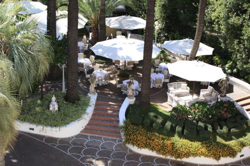 an aerial view of a resort with tables and umbrellas at La Medusa Hotel - Dimora di Charme in Castellammare di Stabia
