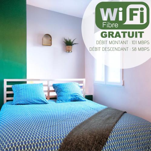 une chambre avec un lit bleu avec des oreillers bleus dans l'établissement NuitéeJour Niort Centre, à Niort