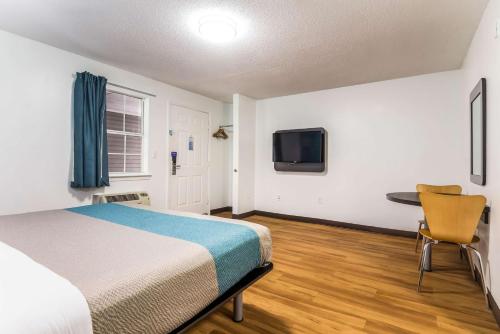 a bedroom with a bed and a desk and a tv at Motel 6-Gulf Shores, AL in Gulf Shores