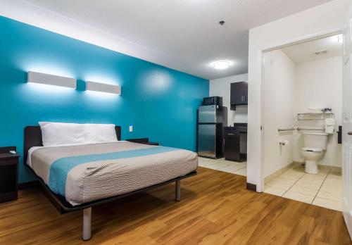 a room with a bed and a blue wall at Motel 6-Gulf Shores, AL in Gulf Shores
