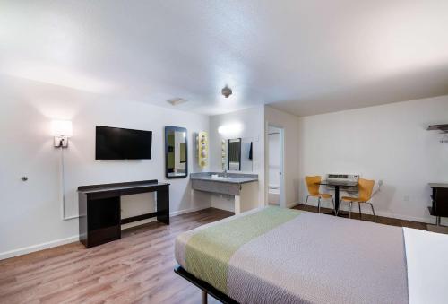 a room with a bed and a desk and a sink at Motel 6-Burlington, WA in Burlington