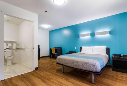 a bedroom with a bed and a blue wall at Motel 6-Gulf Shores, AL in Gulf Shores