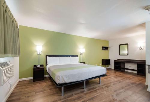 a bedroom with a bed and a green wall at Motel 6-Burlington, WA in Burlington