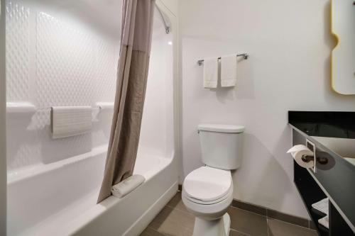 Un baño blanco con inodoro y ducha. en Studio 6-Ingleside, TX, en Ingleside