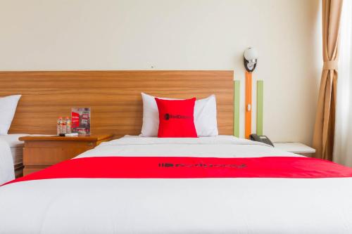 a bedroom with a large bed with a red pillow at RedDoorz Plus @ Surapati 2 in Bandung
