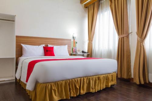 a bedroom with a large bed with red pillows at RedDoorz Plus @ Surapati 2 in Bandung
