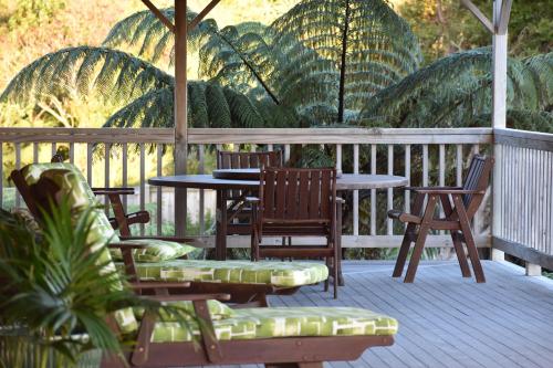 a deck with chairs and a table and chairs at Atea Lodge in Coromandel Town