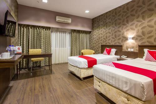 Cette chambre comprend deux lits et un bureau. dans l'établissement Capital O 769 City Hotel, à Balikpapan