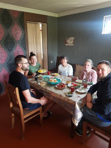 a group of people sitting around a table eating food at wine valley in Udabno