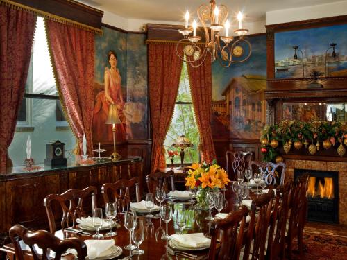a dining room with a long table and a fireplace at Azalea Inn and Villas in Savannah