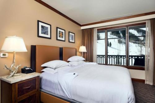 une chambre avec un grand lit blanc et une fenêtre dans l'établissement Ritz-Carlton Club Unit 8402, 2 Bedroom Ski-in/Ski-out Condo in Aspen Highlands, à Aspen