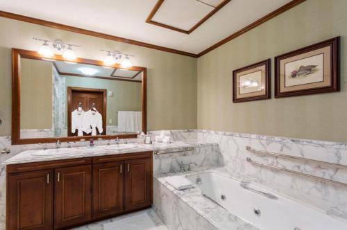 baño con 2 lavabos, bañera y espejo grande en The Ritz-Carlton Club, Two-Bedroom Residence 8410, Ski-in & Ski-out Resort in Aspen Highlands en Aspen