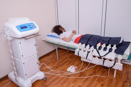 a woman laying on a bed in a hospital room at Arzni Health Resort in Arzni