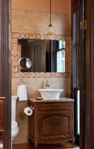 a bathroom with a sink and a toilet and a mirror at Azalea Inn and Villas in Savannah