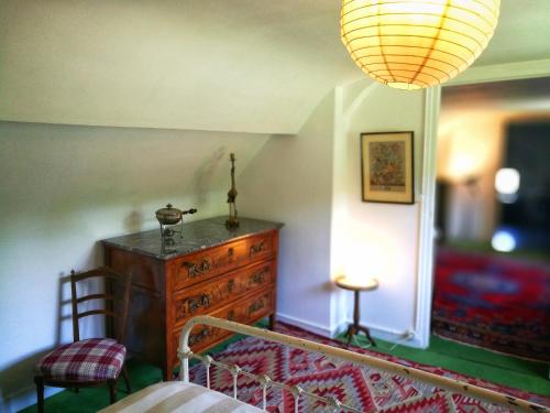 a bedroom with a wooden dresser and a lamp at Gîte d'Aigues Vives in Céré-la-Ronde