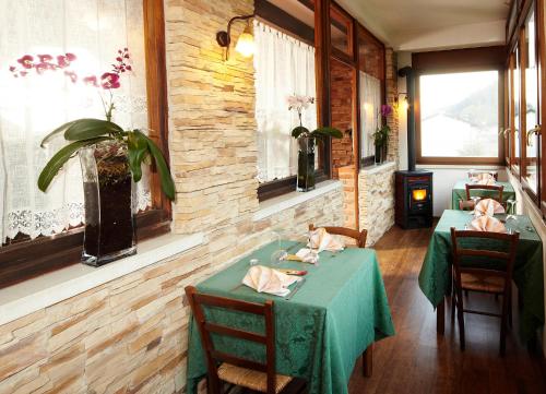 a dining room with two tables and chairs and windows at Locanda Da Luca in Recoaro Terme