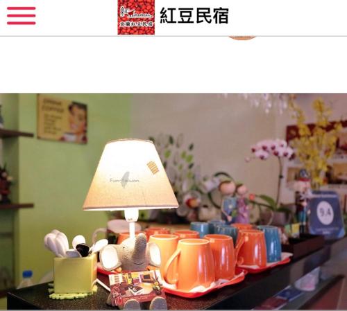 a table with a lamp and a bunch of cups at Redbean Guesthouse in Wujie
