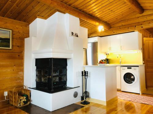 a kitchen with a fireplace in a room with wooden ceilings at Vasa Ski Lodge in Mora