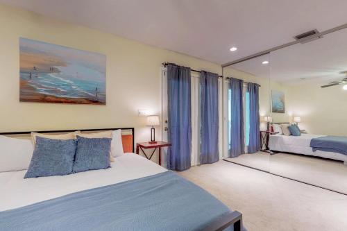 um quarto com 2 camas e cortinas azuis em 3 Bed 4 Bath Apartment in Destin em Destin