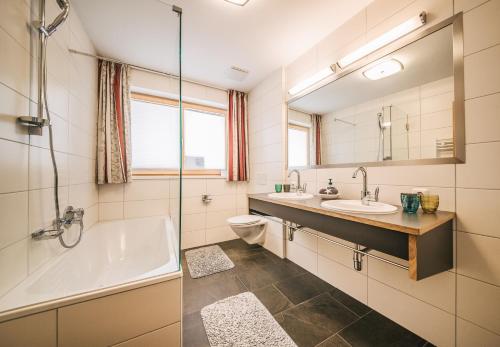 een badkamer met een bad, een wastafel en een toilet bij Haus Hannes Spiss in Sankt Anton am Arlberg