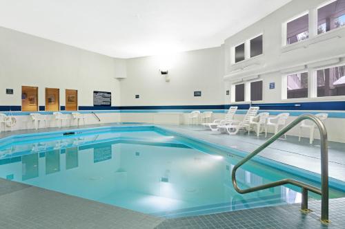 a swimming pool with white chairs in a building at 1 Bed 1 Bath Vacation home in Newry in Newry