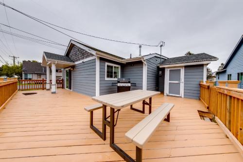 a wooden deck with a bench and a house at Seaside Comforts in Seaside