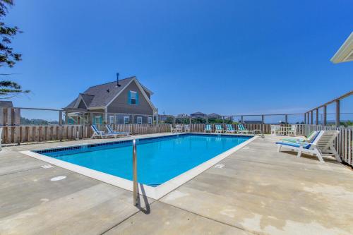 a swimming pool with chairs and a house at Dog Paddle in Lincoln City