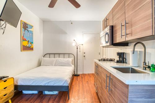 een kleine keuken met een bed en een wastafel bij Ocean Drive Apartments in Miami Beach