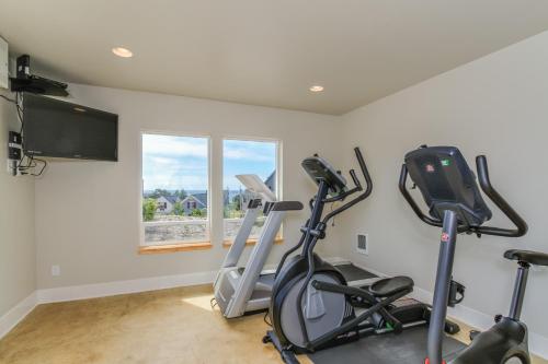 a gym with two exercise bikes and a flat screen tv at Dog Paddle in Lincoln City