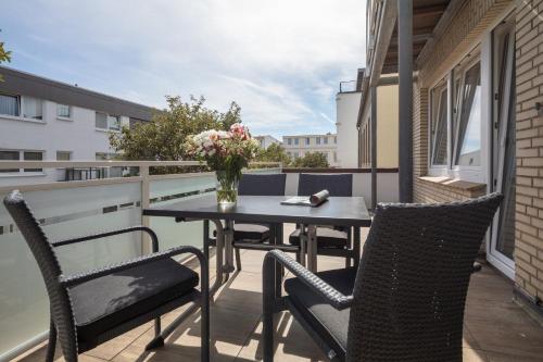 a patio with a table and chairs on a balcony at Villa Christina in Norderney
