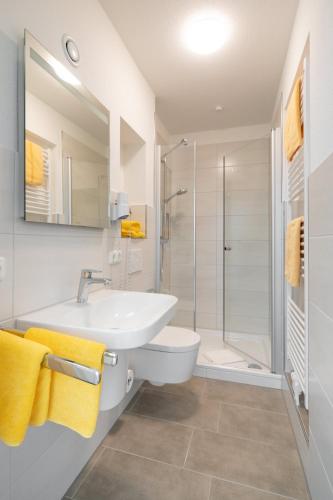 a bathroom with a sink and a toilet and a shower at Villa Christina in Norderney
