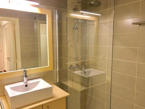 La salle de bains est pourvue d'un lavabo et d'une douche en verre. dans l'établissement Duinenblik 2, à Nieuport