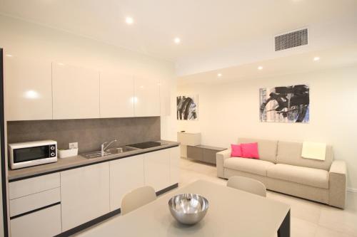 a kitchen and living room with a couch and a table at Casa Vacanze Residence Ideale Suites and Apartments in Alassio