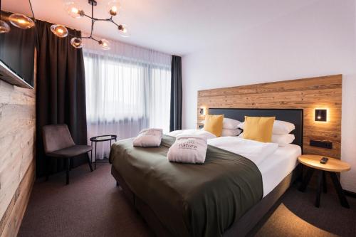 a bedroom with a large bed with two pillows on it at Natura Hotel Bodenmais - inkl Soft- und Heißgetränkeflat in Bodenmais