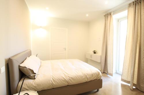 a white bedroom with a bed and a window at Casa Vacanze Residence Ideale Suites and Apartments in Alassio