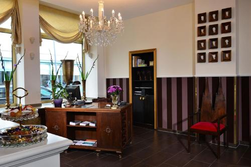 a living room with a table and a chandelier at Hotel Domspitzen in Cologne
