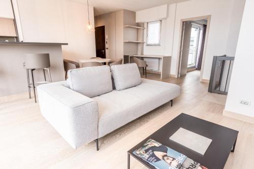 The Residence Gare في لوكسمبورغ: غرفة معيشة مع أريكة بيضاء وطاولة
