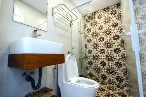 a bathroom with a toilet and a sink and a mirror at SANTORI Hoi An Homestay in Hoi An