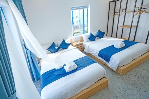two beds in a room with blue and white at SANTORI Hoi An Homestay in Hoi An