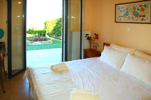 a large white bed with a towel on top of it at Comfy flat with Garden near the Beach in Theológos