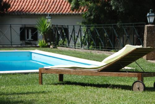 a lounge chair in the grass next to a swimming pool at Sintra Center Guest House Escape to Nature in Sintra