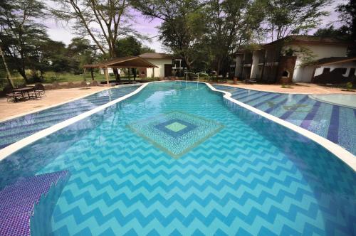 a large swimming pool with a blue and white pattern at Hunters Lodge in Twaandu