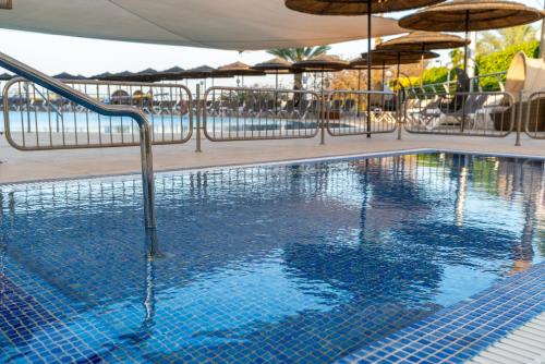a large swimming pool with umbrellas on a resort at Leonardo Plaza Hotel Tiberias in Tiberias