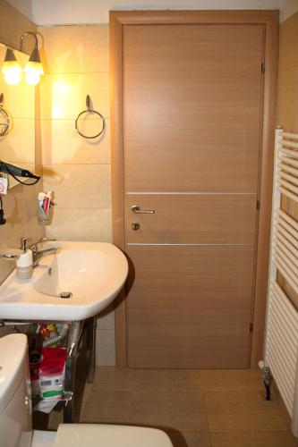 a bathroom with a wooden door next to a sink at Comfy flat with Garden near the Beach in Theológos