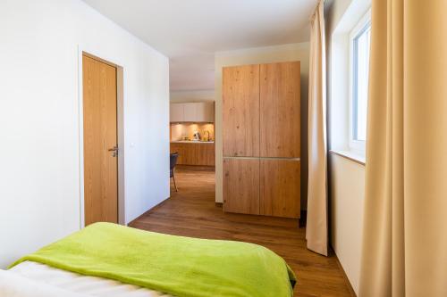 a bedroom with a green blanket on top of a bed at INhouse - Wohnen auf Zeit in Ingolstadt