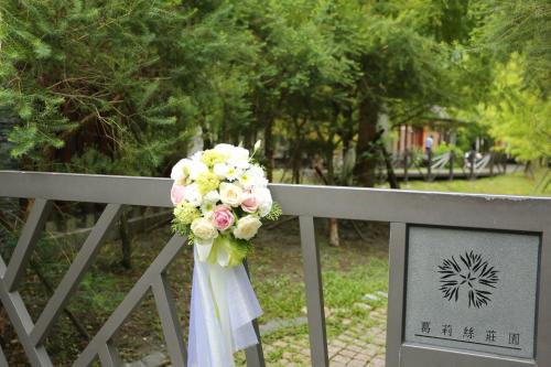 a bouquet of flowers is hanging on a fence at Grace Garden Villa in Fengshan